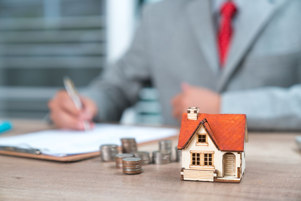 Persoon vult documenten in met huismodel en munten